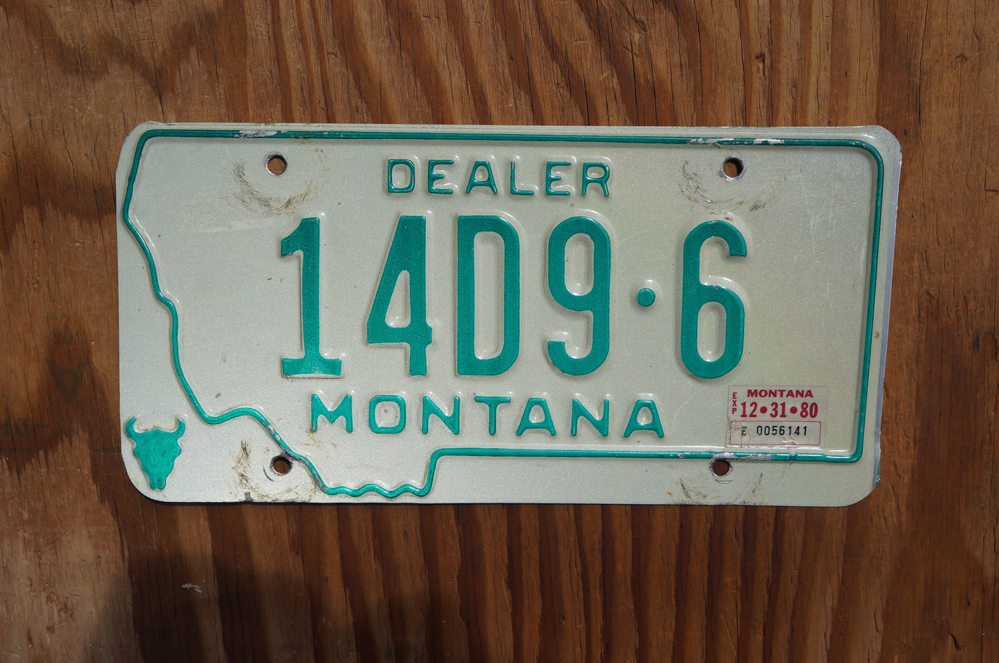 1980 Montana DEALER Silver License Plate State Shape Skull