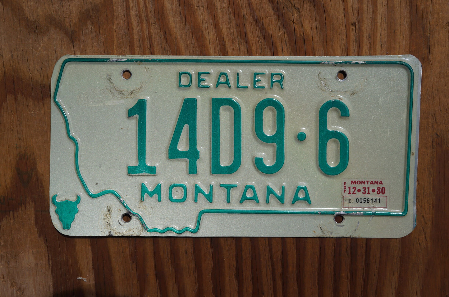 1980 Montana DEALER Silver License Plate State Shape Skull