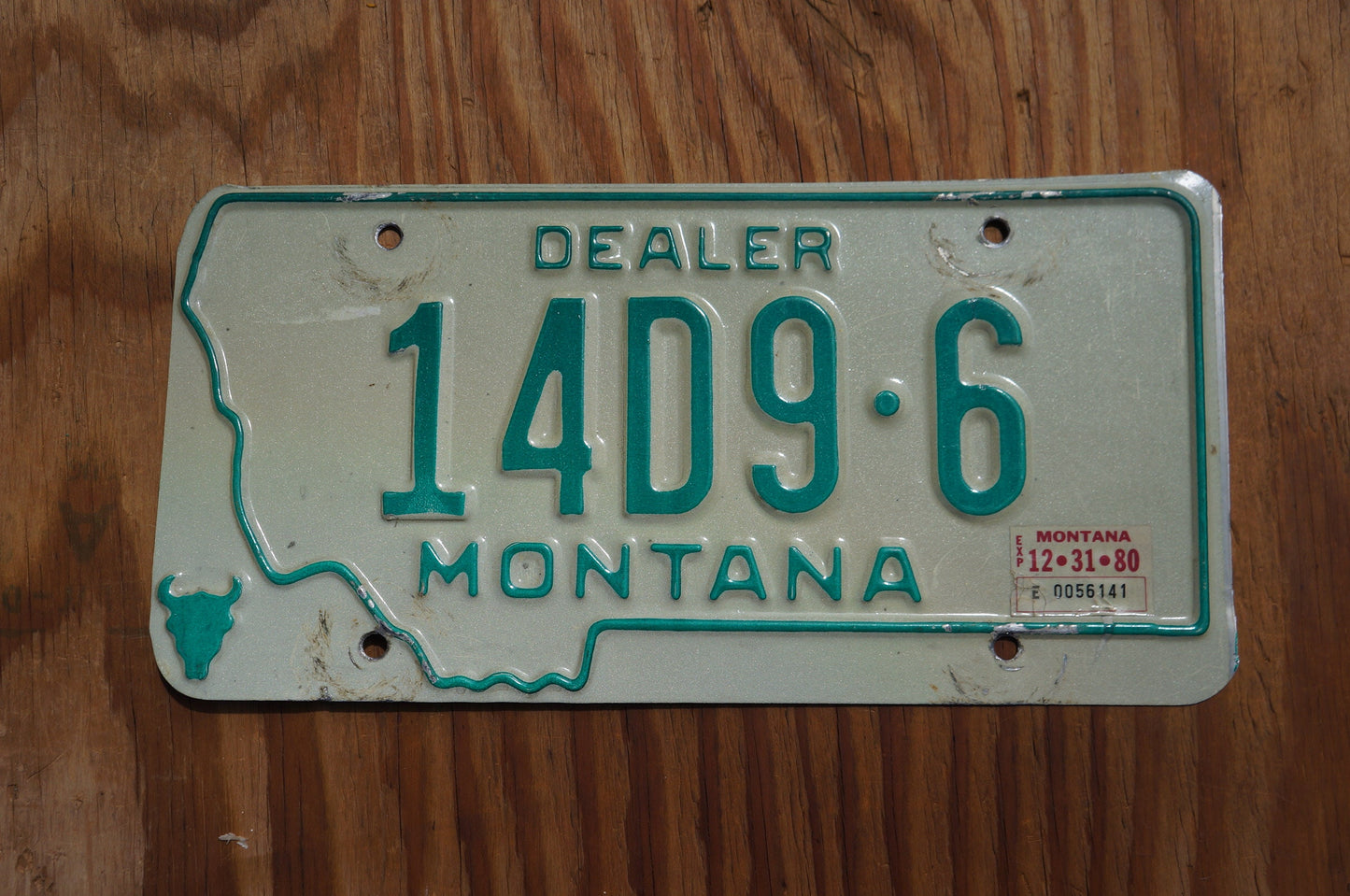 1980 Montana DEALER Silver License Plate State Shape Skull